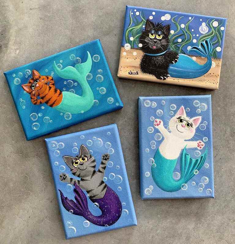 Paintings of cats with mermaid tails.