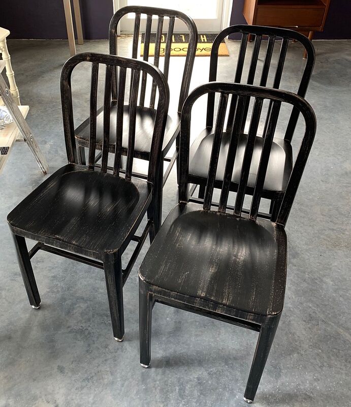 Four black metal dining chairs.