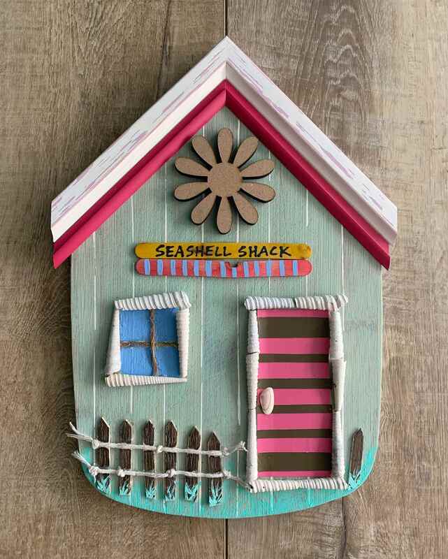 Small beach home wall art with pink seashell and flower theme.